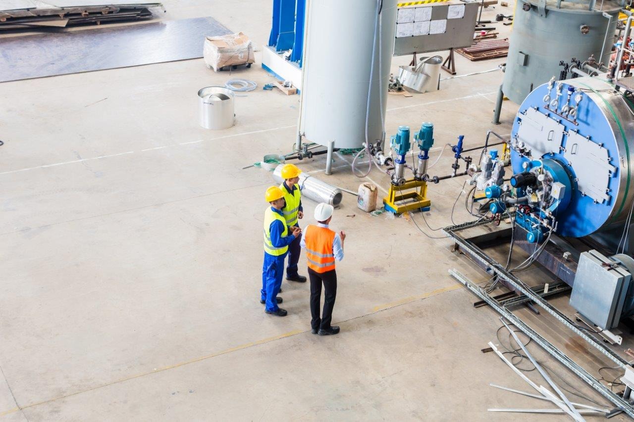 Drei Fabrikarbeiter bei der Arbeit